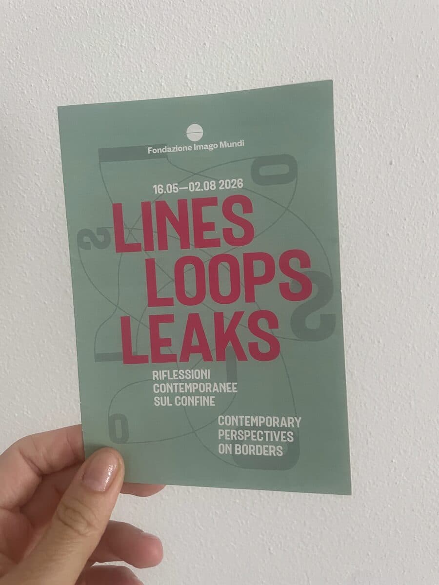 The green leaflet of the exhibition Lines, Loops, Leaks, held in one hand
