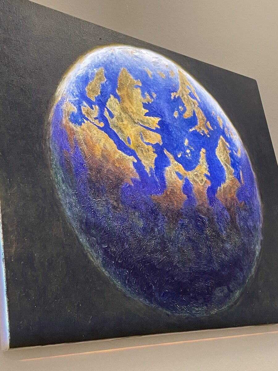 Painting of a blue and gold planet suspended against a dark background